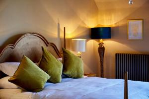 ein Schlafzimmer mit einem Bett mit grünen Kissen in der Unterkunft The Bowl Inn in Charing