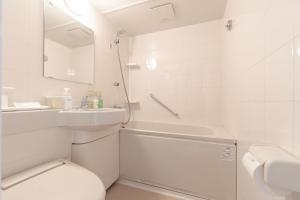 a white bathroom with a toilet and a sink at Hotel Gimmond Kyoto in Kyoto +32 photos