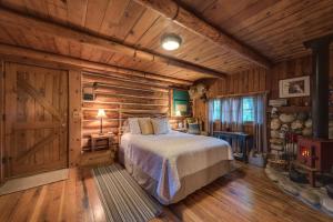 1 dormitorio con 1 cama y pared de madera en The Davies Family Inn, en Placerville