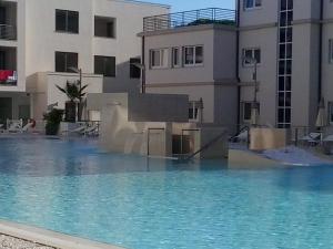 a large swimming pool in front of a building at Hotel Terme Marine Leopoldo II TERME & SPA in Marina di Grosseto