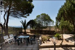 a patio with a table and chairs and trees at Casa Sulky SantAntioco in Maladroscia