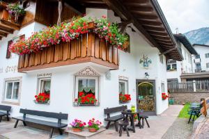 a building with benches and flowers on it at Garni Crepaz in Selva di Val Gardena