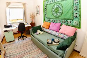 een woonkamer met een groene bank en kleurrijke kussens bij Sinidio in Lucca