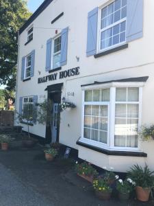 Um edifício branco com uma placa de Harley House. em Halfway House em Great Malvern