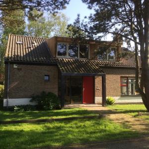 ベルゲンにあるB&B PeperZzzの赤い扉のあるレンガ造りの家