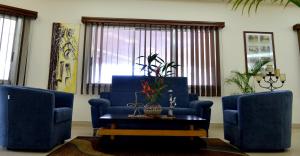 a living room with two blue chairs and a table at The Cape Hotel in Monrovia