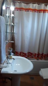 a bathroom with a sink and a shower curtain at ★ Meniko's House ★ Amazing Sea View in Himare +8 photos