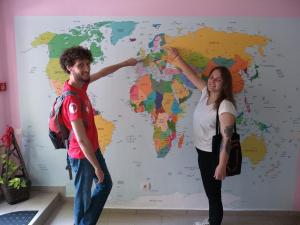 Un uomo e una donna in piedi davanti a una mappa del mondo di Smart Hostel Sofia a Sofia