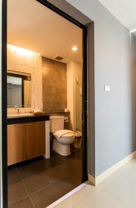 a bathroom with a toilet and a sink and a mirror at Jira Boutique Residence in Chiang Mai