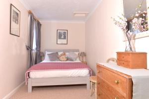 a bedroom with a bed with a teddy bear on it at Littledale Haven in Eastbourne