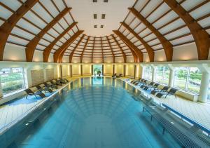 una gran piscina con sillas y un gran techo en Hotel Stok, en Wisła