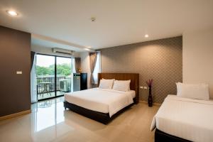 a hotel room with two beds and a balcony at Jira Boutique Residence in Chiang Mai +51 photos