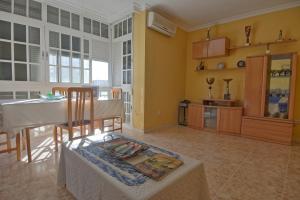 sala de estar con mesa y cocina en Habitación en casa compartida, en Huelva