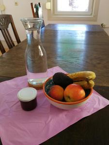 a bowl of fruit on a table with a bottle at Ferienwohnung Burg Lindenfels in Lindenfels