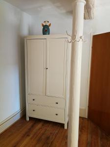 ein weißer Schrank mit einer Vase darüber in der Unterkunft Ferienwohnung Burg Lindenfels in Lindenfels