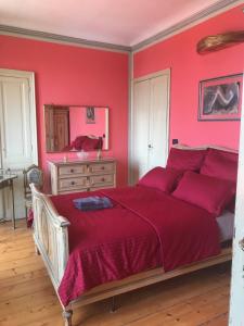 ein rotes Schlafzimmer mit einem Bett und einer Kommode in der Unterkunft Villa Monferrato in Passerano 