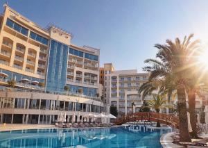 a resort with a swimming pool and palm trees and buildings at Splendid Conference & Spa Resort in Budva