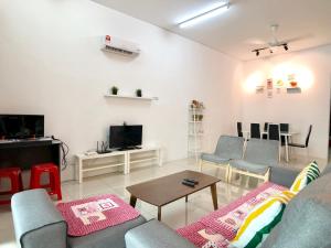 een woonkamer met een bank en stoelen en een tv bij Kampar Sakura 3 Landed in Kampar