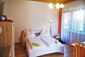 - une chambre avec un lit doté de draps et d'oreillers blancs dans l'établissement Mental-Oase Haunold, à Erpfendorf