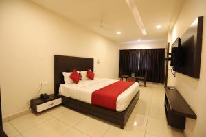 a hotel room with a bed and a television at Traders Hotel - Kankanady, Mangalore in Mangalore
