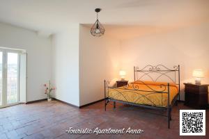 um quarto com uma cama e duas mesas e um candeeiro em Tourist Apartment Anna em Bracciano
