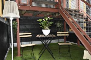 een patio met 2 stoelen en een tafel met een potplant bij B&B de Gusto in Schiedam