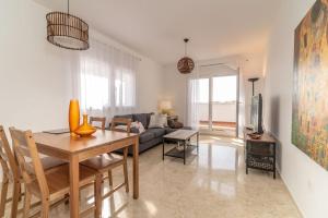 uma sala de estar com uma mesa e um sofá em Recently Decorated 2BDR Penthouse in Fuengirola em Fuengirola