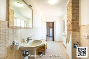 uma casa de banho com um lavatório e um espelho em Tourist Apartment Anna em Bracciano