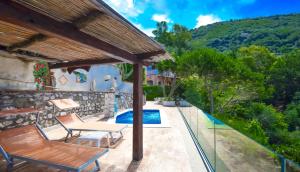 マッサ・ルブレンセにあるAmore Rentals - Villa Baccoのパティオ(テーブル、椅子付)、プールが備わります。