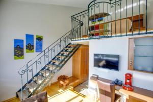 a staircase in a living room with a dog standing under it at Hotel Glymur in Leirá