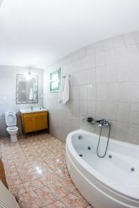 a bathroom with a tub and a toilet and a sink at Casa Mare in Nimfaíon