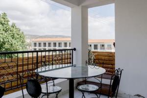 a patio with a table and chairs on a balcony at Spacious 2 bedroom apartment in Peyia