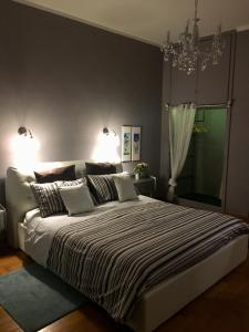 1 dormitorio con 1 cama grande y lámpara de araña en a casa di Narciso e Margherita, en Foligno
