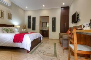 a bedroom with a bed, chair, and a desk at Forest Lodge in St Lucia