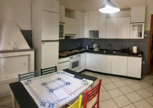 a kitchen with white cabinets and a table with chairs at a casa di Narciso e Margherita in Foligno