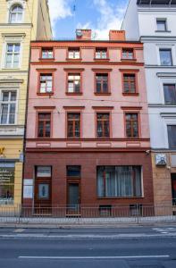 un edificio de ladrillo rojo al lado de una calle en Five Stars Bed&Breakfast, en Wroclaw