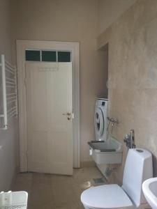 a bathroom with a white toilet and a sink at Rotzowlund BnB in Grenå