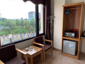 a room with a table and chairs and a window at Dragon Airport Hotel in Noi Bai