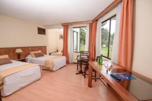um quarto de hotel com duas camas e uma janela em Hotel del Valle Azapa em Arica