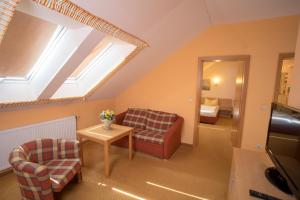 a attic room with a couch and a table at Landhaus & Landhof Gabriel in Bülstringen