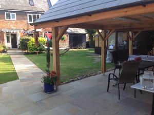 a wooden pavilion with a table in a yard at Cowes - The Barn in Cowes