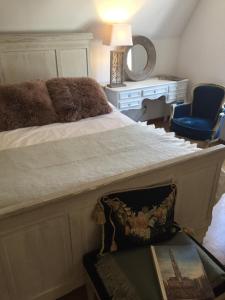 ein Schlafzimmer mit einem Bett, einem Stuhl und einem Spiegel in der Unterkunft Brugge’s House of Friends in Brügge
