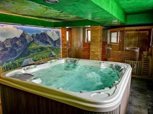 jacuzzi en una habitación con un mural de montaña en Domki U Śliwioka, en Szaflary 50 fotos más