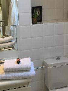 a bathroom with a toilet and towels and a mirror at Brugge’s House of Friends in Bruges