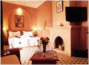 um quarto de hotel com uma cama e uma lareira em Riad La Rose D'orient em Marraquexe