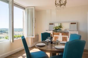une salle à manger avec une table et des chaises bleues dans l'établissement Bellevue appartement, à Ayen