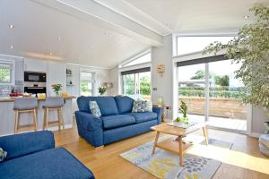 a living room with a blue couch and a table at Perry Lodge, Strawberryfield Park in Cheddar