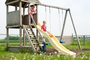 two children playing on a slide at a playground at Newhouse Logies in Zevenhoven