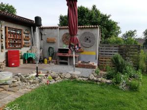 een tuin met een patio met een parasol in een tuin bij Studio Apartments Korosteljev in Osijek