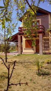 una casa con un árbol delante de ella en Cabañas Vientos del Sur en Villa Yacanto